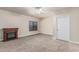 Bedroom featuring an electric fireplace, window, ceiling fan, and neutral colored carpet and walls at 3457 E Ellis St, Mesa, AZ 85213