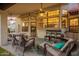 Inviting covered patio featuring comfortable seating, ceiling fans, and view of outdoor kitchen area at 3457 E Ellis St, Mesa, AZ 85213