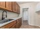Well-lit laundry room with wood cabinets, tile flooring and stainless steel sink with modern black faucet at 3457 E Ellis St, Mesa, AZ 85213