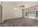 Inviting living room with carpet flooring, sliding glass doors to the pool, and bright natural light at 3457 E Ellis St, Mesa, AZ 85213