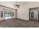 Large living room with carpet flooring and sliding doors that open to a pool area at 3457 E Ellis St, Mesa, AZ 85213