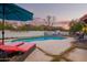Backyard pool with clear blue water, surrounded by lounge chairs and umbrella, perfect for relaxation at 3457 E Ellis St, Mesa, AZ 85213
