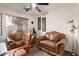 Home office with two brown leather sofas and a ceiling fan at 42930 W Samuel Dr, Maricopa, AZ 85138