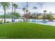 Expansive backyard with lush lawn, pool, and palm trees at 4639 E Mountain View Ct, Phoenix, AZ 85028