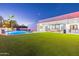 Luxury backyard oasis with a sparkling pool, artificial turf, and covered patio at 4639 E Mountain View Ct, Phoenix, AZ 85028