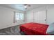 Bedroom with a red bedspread, gray carpet, and plenty of closet space at 4639 E Mountain View Ct, Phoenix, AZ 85028