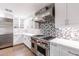 Modern kitchen with stainless steel appliances and mosaic backsplash at 4639 E Mountain View Ct, Phoenix, AZ 85028