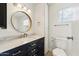 Bathroom with a large round mirror and dark vanity at 5428 E El Sendero Dr, Cave Creek, AZ 85331
