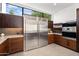 Modern kitchen features stainless steel appliances and dark wood cabinetry at 5825 E Cochise Rd, Paradise Valley, AZ 85253