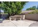 Relaxing backyard featuring a custom concrete bench, mature landscaping, and privacy wall at 5951 W Irma Ln, Glendale, AZ 85308