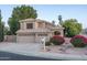 Charming home showcasing a tiled roof, three-car garage, and desert landscaping with vibrant bougainvillea bushes at 5951 W Irma Ln, Glendale, AZ 85308