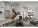 Open-concept living room with staircase, modern design elements, and natural light filled dining area at 5951 W Irma Ln, Glendale, AZ 85308