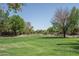 Large grassy park area with mature trees and walking paths at 5951 W Irma Ln, Glendale, AZ 85308