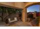 Relaxing covered patio with a swing and manicured landscaping at dusk at 5951 W Irma Ln, Glendale, AZ 85308