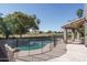 Backyard pool and patio area with lush greenery and mature landscaping, perfect for relaxing at 5951 W Irma Ln, Glendale, AZ 85308