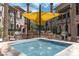 Community pool with patio tables, grills, and shade structure at 6565 E Thomas Rd # 1005, Scottsdale, AZ 85251