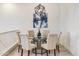 Elegant dining room with a glass-top table and six light beige chairs at 6565 E Thomas Rd # 1005, Scottsdale, AZ 85251