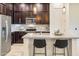 Modern kitchen with dark cabinetry, stainless steel appliances, and a kitchen island at 6565 E Thomas Rd # 1005, Scottsdale, AZ 85251