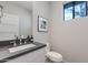 This half bathroom features a modern vanity and framed mirror at 6990 E 6Th St # 1005, Scottsdale, AZ 85251