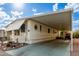 Mobile home with carport and landscaped yard at 9333 E University Dr # 55, Mesa, AZ 85207