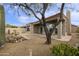 Desert landscape with a large tree, stone pathway and water feature at 9514 E Cavalry Dr, Scottsdale, AZ 85262