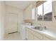 Laundry room with washer, dryer, sink, and built-in cabinets at 9514 E Cavalry Dr, Scottsdale, AZ 85262