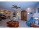 Spacious living room with multiple seating areas and a ceiling fan at 9614 N 110Th Ave, Sun City, AZ 85351