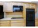 Well-equipped kitchen with black appliances and wood cabinets at 10529 W Pineaire Dr, Sun City, AZ 85351