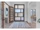 Elegant entryway with a modern glass and metal door, wood door, and tile flooring at 14236 E Ranch Rd, Scottsdale, AZ 85262
