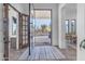 Bright entryway with wood and glass doors, view of backyard, and tile flooring at 14236 E Ranch Rd, Scottsdale, AZ 85262