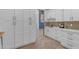 White kitchen with built-in coffee bar and ample storage at 14236 E Ranch Rd, Scottsdale, AZ 85262