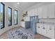 Laundry room with dog wash, white cabinets, and blue tile backsplash at 14236 E Ranch Rd, Scottsdale, AZ 85262