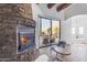 Living room with a stone fireplace and sliding glass doors to patio at 14236 E Ranch Rd, Scottsdale, AZ 85262