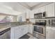 Modern kitchen with white cabinets, granite counters, and stainless steel appliances at 1976 S 172Nd Ln, Goodyear, AZ 85338