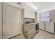 Laundry room with washer, dryer, cabinets, and storage at 1976 S 172Nd Ln, Goodyear, AZ 85338
