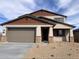 Two-story home showcasing a two-car garage, neutral stucco, and stone column accents at 20631 N 226Th Ln, Surprise, AZ 85387