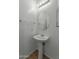 Small bathroom with pedestal sink and round mirror at 21150 W Prospector Way, Buckeye, AZ 85396