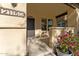 Inviting house exterior with a covered porch, landscaped flower bed, and a security door at 21150 W Prospector Way, Buckeye, AZ 85396