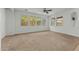 Bright living room with neutral carpet, ceiling fan, and large windows at 21150 W Prospector Way, Buckeye, AZ 85396