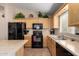 Modern kitchen with black appliances and light wood cabinets at 23944 N High Dunes Dr, Florence, AZ 85132