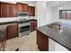 Kitchen with dark wood cabinets, granite countertops, and stainless steel appliances at 3305 S 122Nd Ln, Tolleson, AZ 85353