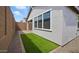 Low-maintenance backyard featuring artificial turf, gravel landscaping, and a neutral-toned exterior at 4380 N 203Rd Dr, Buckeye, AZ 85396