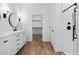 Bathroom with dual sinks, modern fixtures, and open access to the closet at 4380 N 203Rd Dr, Buckeye, AZ 85396