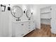 Bathroom featuring double sinks, wood floors and a large mirror at 4380 N 203Rd Dr, Buckeye, AZ 85396