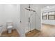 Modern bathroom featuring a glass shower, wood-look tile flooring, and contemporary fixtures at 4380 N 203Rd Dr, Buckeye, AZ 85396