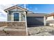 Charming home featuring a gray two-car garage, stone accents, and a beautifully paved driveway at 4380 N 203Rd Dr, Buckeye, AZ 85396