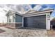 A gray two-car garage with paved driveway complements the home's exterior, featuring stone accents at 4380 N 203Rd Dr, Buckeye, AZ 85396