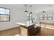 An open kitchen featuring an island with a sink, wood floors, and stainless steel appliances at 4380 N 203Rd Dr, Buckeye, AZ 85396
