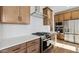Close up of kitchen featuring stainless steel appliances, wood cabinets, and white subway tile backsplash at 4380 N 203Rd Dr, Buckeye, AZ 85396