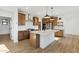 An open kitchen featuring wood cabinets, stainless steel appliances, an island, and wood floors at 4380 N 203Rd Dr, Buckeye, AZ 85396